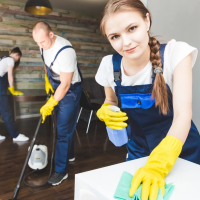 Give your photo a description: "A professional cleaning team in Georgetown, TX is working together to clean a home. One cleaner is vacuuming the floor while another is wiping down a table. This image highlights the efficiency and teamwork involved in our maid services. Learn more about the cost of maid services in Georgetown, TX, and how we provide quality cleaning solutions.