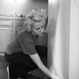 A professional cleaner tidying a modern home in Round Rock, TX, using high-quality supplies to save the homeowner time and reduce daily stress.